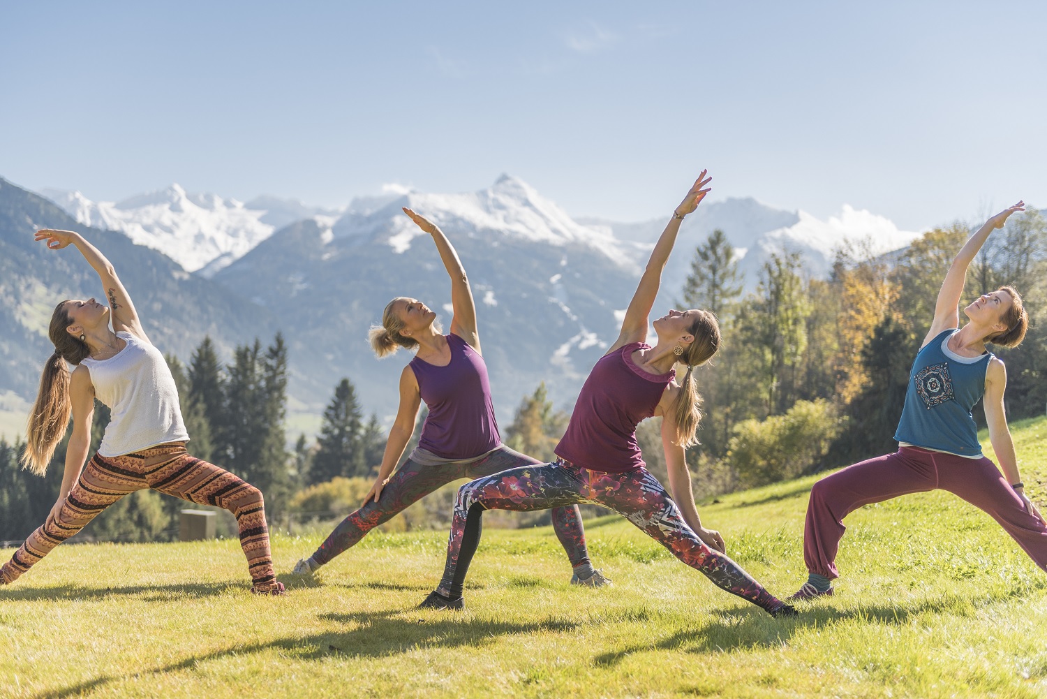 4 Frauen betreiben Yoga auf einer Wiese